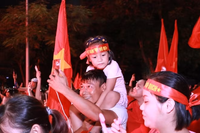 Những em bé theo bố mẹ đi ăn mừng chiến thắng.