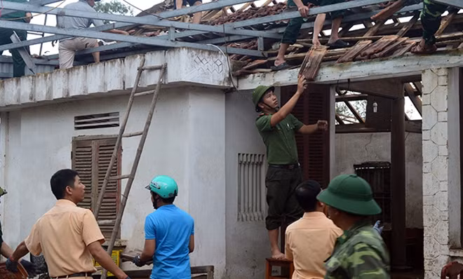 Giúp dân sửa nhà sau bão.