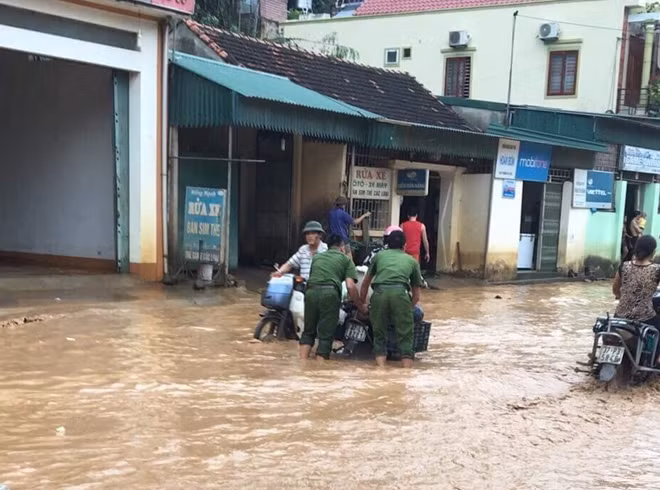 CBCS Công an huyện Kỳ Sơn giúp dân di chuyển phương tiện qua chỗ mưa ngập.