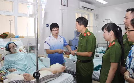 Đại tá Vũ Hồng Văn và cán bộ đoàn công tác thăm hỏi, động viên người mẹ trẻ kiên cường.