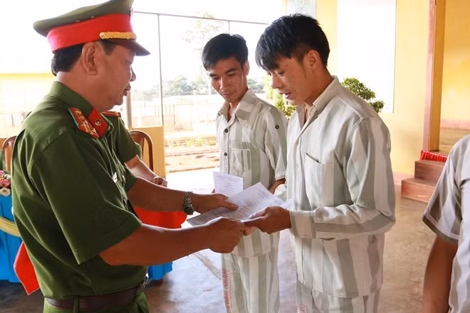 Đại tá Đặng Duy Văn, Giám thị Trại giam Đắk Trung trao giấy chứng nhận đặc xá cho các phạm nhân.