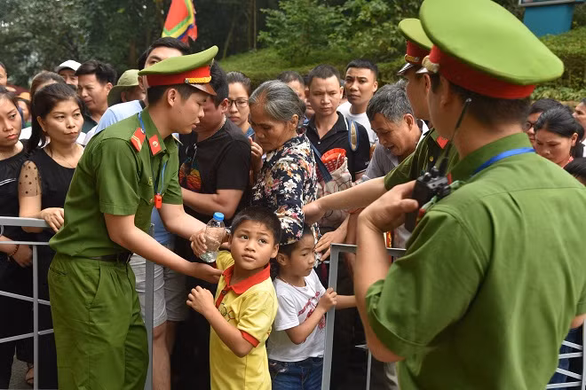 CBCS Công an hỗ trợ các em nhỏ và đồng bào di chuyển vào khu vực Đền Hùng.