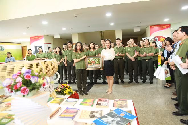 Đại úy Đỗ Thu Thơm, Phó Giám đốc Thư viện CAND nhận quà từ Công ty cổ phần Tư liệu Việt.