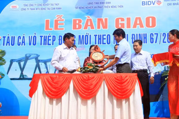 Đại diện Công ty TNHH MTV Đóng tàu Cam Ranh và ngư dân Nguyễn Việt Hàng ký kết biên bản bàn giao tàu cá vỏ thép.