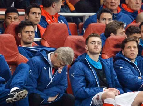 HLV Wenger (giữa) cúi đầu buồn bã.