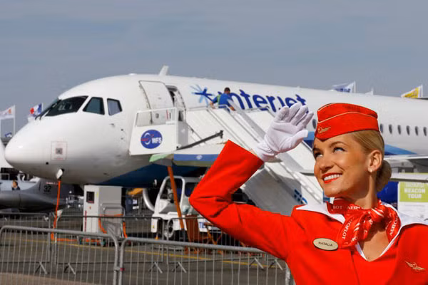 Một nhân viên của hãng hàng không Aeroflot. Đằng sau cô là một máy bay của hãng Sukhoi, không phải chiến đấu cơ mà một máy bay chở khách Sukhoi Superjet 100. Ảnh: Reuters
