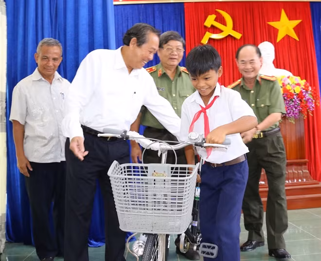 Phó Thủ tướng Trương Hòa Bình cùng Đại tá Trần Kim Thẩm, Phó Tổng Biên tập Báo CAND và các thành viên đoàn công tác tặng xe đạp học sinh nghèo huyện Ba Tơ, Quảng Ngãi.