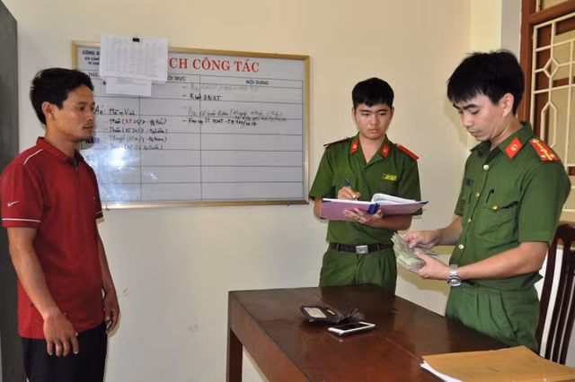 Công an huyện Kim Sơn kiểm tra số tiền mà đối tượng Hoa Văn Thám cưỡng đoạt của nạn nhân