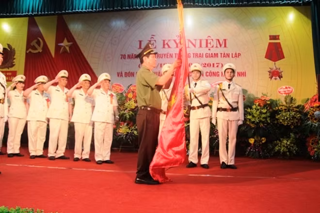 Thừa ủy quyền của Chủ tịch nước, Thứ trưởng Nguyễn Văn Sơn gắn Huân chương chiến công hạng Nhì lên lá cờ truyền thống của Trại giam Tân Lập