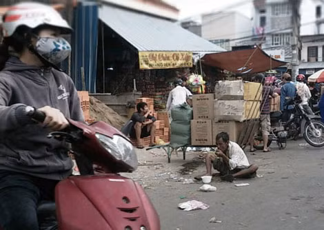 Người đàn ông này sau khi ăn xong tô cháo lại tiếp tục đi xin tiền những người đi chợ.