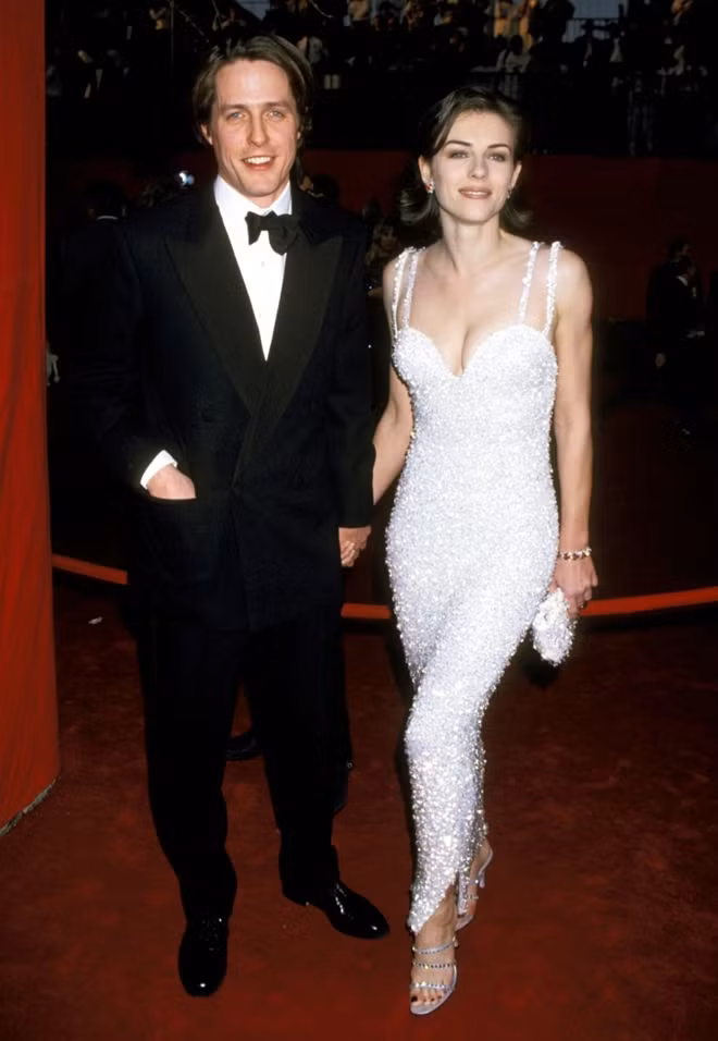 Elizabeth Hurley trong bộ váy trắng đính pha lê tinh xảo của Versace (Oscar 1955).