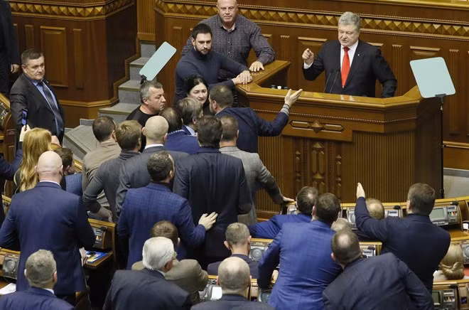 Nhiều nghị sĩ đã phong tỏa bục chủ tọa sau giờ khai mạc phiên toàn thể Quốc hội Ukraine để phản đối sắc lệnh thiết quân luật của ông Poroshenko. Ảnh: Reuters.