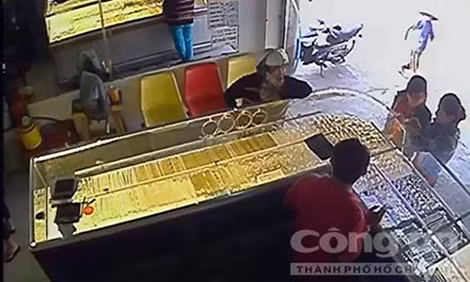 Oanh (đội nón bảo hiểm) đem tài sản cướp được đi bán. Ảnh: Công an TP Hồ Chí Minh. Oanh (đội nón bảo hiểm) đem tài sản cướp được đi bán. Ảnh: Công an TP Hồ Chí Minh.