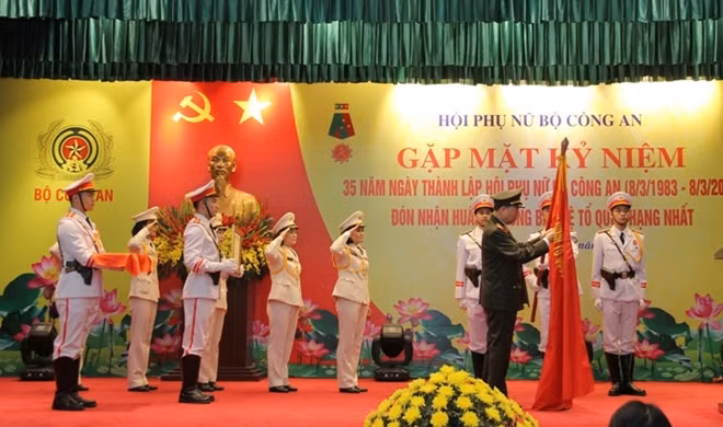 Bộ trưởng Tô Lâm gắn Huân chương Bảo vệ Tổ quốc hạng Nhất lên lá cờ truyền thống của HPN Bộ Công an
