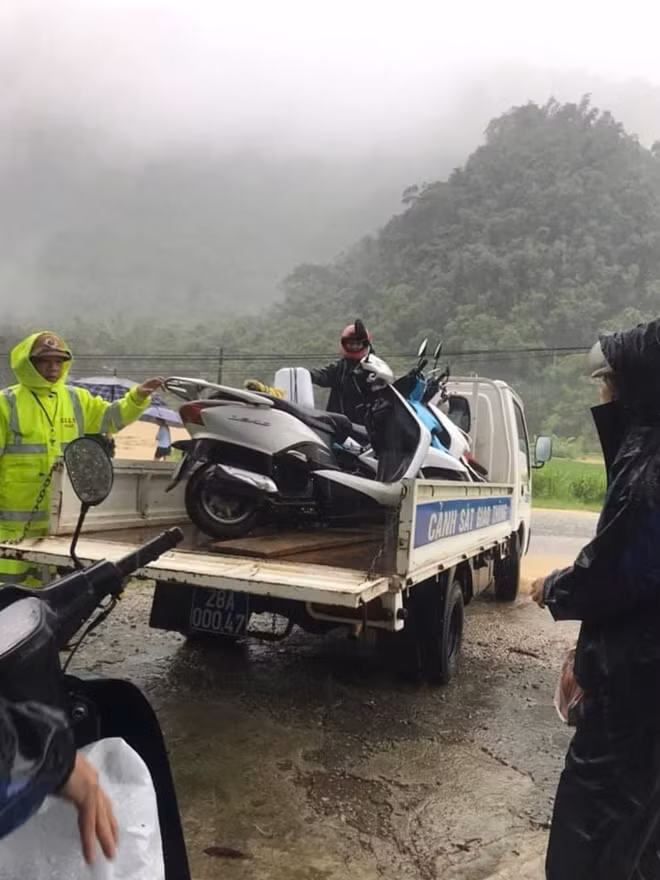 Cảnh sát giao thông Công an huyện Mai Châu sử dụng xe ô tô chở phương tiện của người dân qua vùng ngập