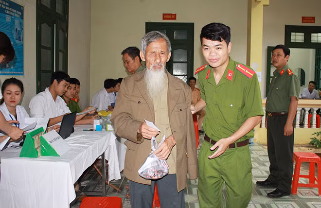 Cán bộ Công an huyện Yên Thủy giúp đỡ người dân trong buổi khám, chữa bệnh miễn phí.
