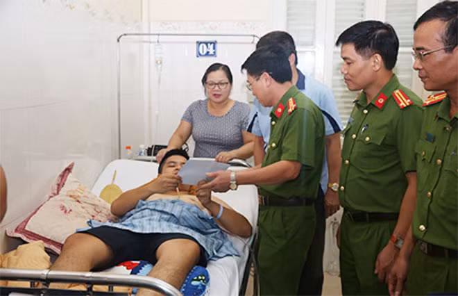 Đại tá Vũ Văn Đông tặng quà, động viên Thiếu úy Phạm Văn Chính.