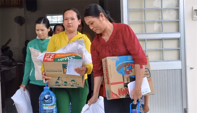 Người dân vui mừng mang phần quà cứu trợ về nhà.