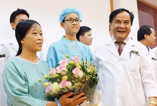 GS Bùi Đức Phú - GĐ Bệnh viện ĐKQT Vinmec Times City tặng hoa cho chị Huyền và con trai trong ngày xuất viện.