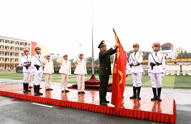 Thứ trưởng Nguyễn Văn Thành gắn Huân chương Bảo vệ Tổ quốc hạng Nhất lên lá Cờ truyền thống.