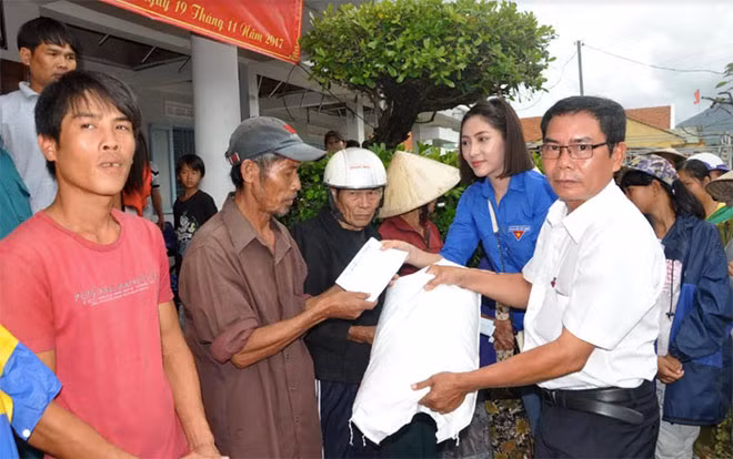 Nhà báo Hữu Toàn – Đại diện Báo CAND cùng Hoa hậu 2014 Đặng Thu Thảo trao quà cứu trợ cho người dân ở xã Xuân Sơn, huyện Vạn Ninh (Khánh Hòa).