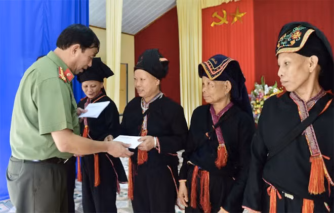 Đại diện Phòng Bảo vệ các đồng chí lãnh đạo Đảng, Nhà nước trao tặng quà cho bà con vùng lũ huyện Văn Yên.