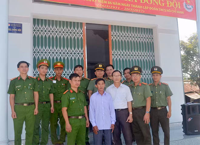 Đại biểu và gia đình đồng chí Lê Trọng Duy vui mừng trước căn Nhà đồng đội.