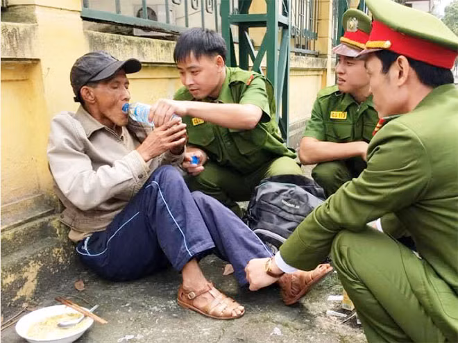 Lực lượng CS 113 chăm sóc ông Hồng bị ngất xỉu trước cổng trường Đại học Thương mại.