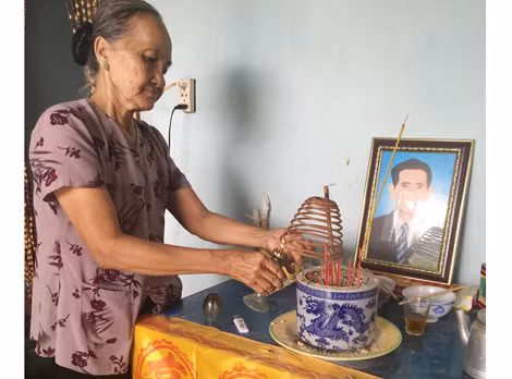 Bà Rinh trước di ảnh của chồng.