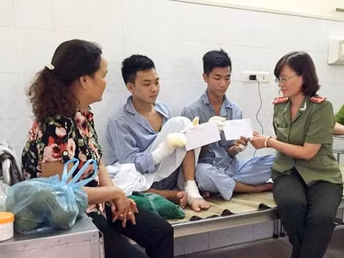 Đại diện Báo CAND trao quà cho đồng chí Nguyễn Văn Quang và Triệu Hoàng Duy.