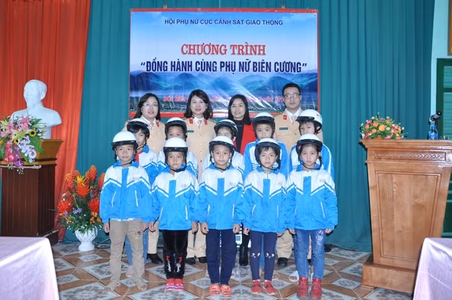 Hội phụ nữ Cục CSGT tặng mũ bảo hiểm cho các cháu học sinh.