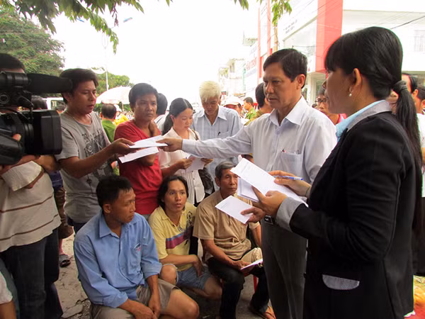 Lãnh đạo UBND huyện Tam Nông trao tiền hỗ chợ cho các tiểu thương.