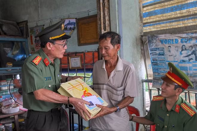 Đại tá Phạm Văn Dư, Phó Hiệu trưởng trường Đại học ANND trao tặng quà cho các gia đình chính sách tại huyện Trà Ôn.