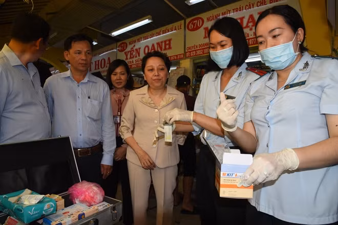 Đoàn công tác lấy mẫu mứt Tết (quả Năng) thử test nhanh ngay tại chợ Bình Tây cho kết quả âm tính.