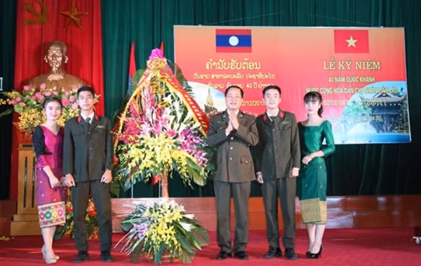 Thiếu tướng, PGS. TS Đỗ Ngọc Cẩn, Phó Tổng cục trưởng Tổng cục Chính trị CAND tặng hoa chúc mừng ngày Quốc khánh cho lưu học sinh Lào.
