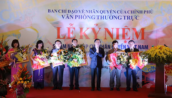 Thứ trưởng Thường trực Đặng Văn Hiếu tặng hoa Ban biên tập Tạp chí Nhân quyền Việt Nam.