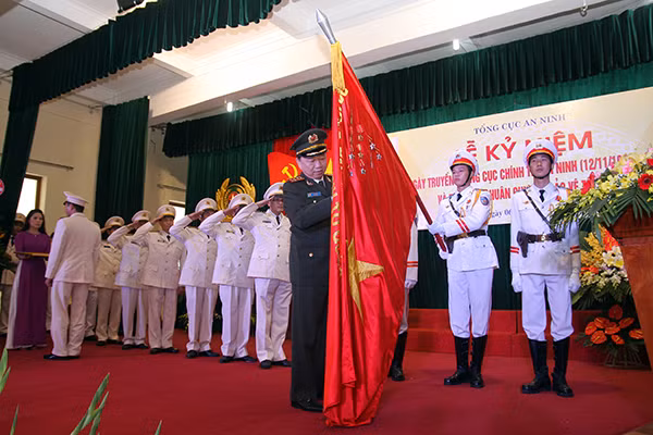 Thứ trưởng Tô Lâm gắn Huân chương Bảo vệ Tổ quốc hạng Nhì lên Cờ truyền thống Cục Chính trị An ninh. Ảnh Việt Hưng.