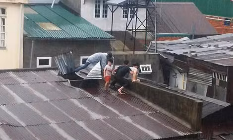 Hiện trường lúc anh Sơn và anh Phong giải cứu gia đình chị Hằng từ mái nhà trong mưa lũ.