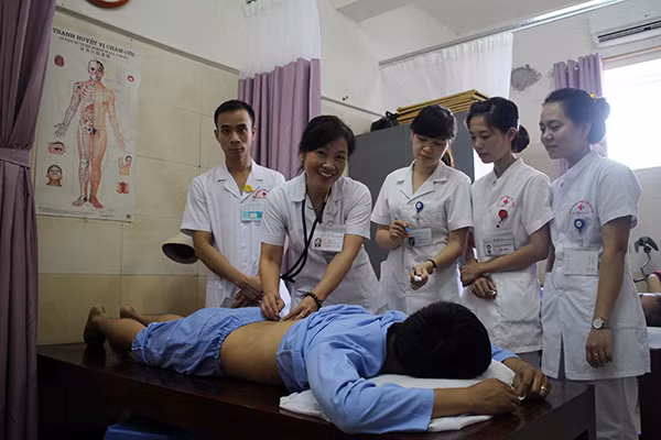 Bác sĩ Trần Thị Quyên thăm khám một bệnh nhân và hướng dẫn kỹ thuật châm cứu cho các đồng nghiệp.