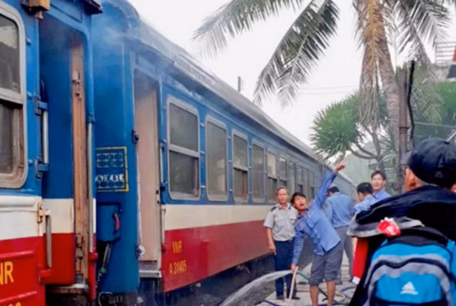 Nhân viên đoàn tàu và nhân viên ga Hảo Sơn phun nước dập tắt hỏa hoạn trên toa xe số 3