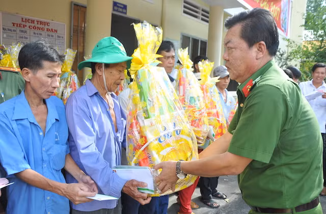 Đại tá Bùi Văn Xứ - Trưởng Công an huyện Vĩnh Thuận trao quà tết cho người dân.