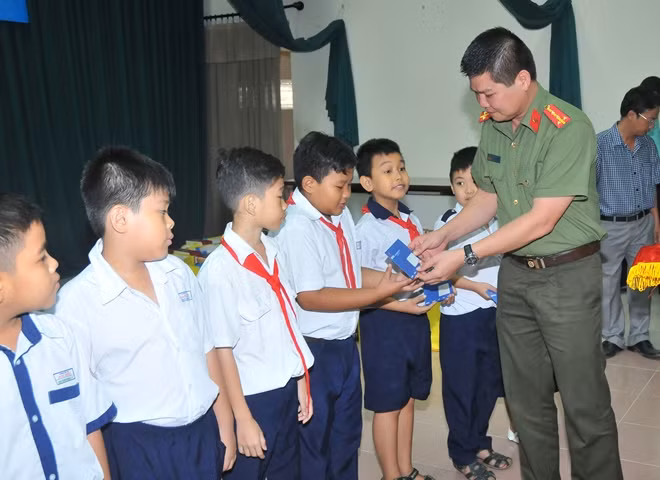 Đại úy Nguyễn Văn Bình – Phó Trưởng Cơ quan đại diện Báo CAND tặng học bổng cho học sinh dân tộc Chăm, TP Hồ Chí Minh.