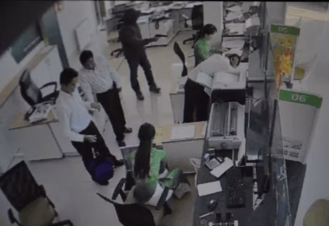 Nghi phạm cầm súng liên tục chĩa về phía các nhân viên ngân hàng.