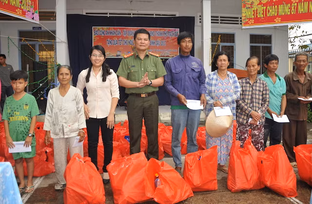 Đại uý Nguyễn Văn Bình, Phó trưởng CQĐD Báo CAND tại TP Hồ Chí Minh cùng bà Nguyễn Thị Hồng Linh – Phó Chủ tịch UBND TP Rạch Giá trao quà cho người dân.
