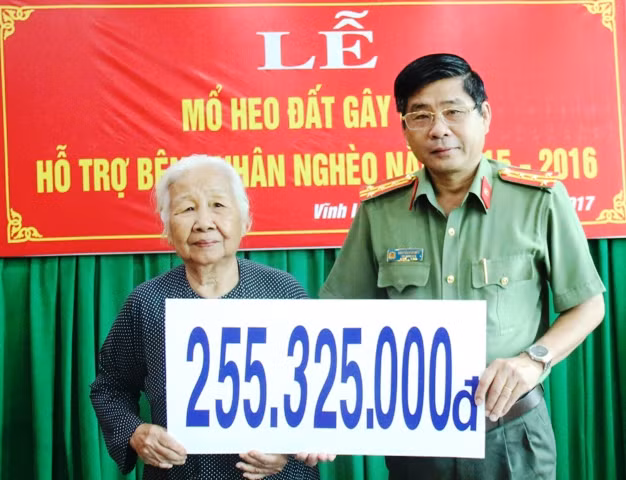 Đại tá Nguyễn Văn Hiểu – Phó Giám đốc Công an tỉnh Vĩnh Long trao số tiền mổ heo đất cho đại diện Hội Bảo trợ bênh nhân nghèo.