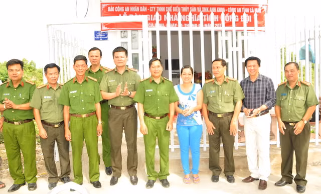 Đại diện Báo CAND, Ban giám đốc Công an tỉnh Cà Mau và lãnh đạo Công ty TNHH chế biến Thuỷ sản và XNK Anh Khoa trao nhà cho gia đình Đại uý Huỳnh Minh Tặng.