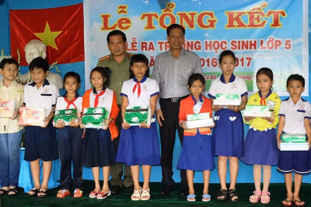 Thượng tá Đinh Văn Nơi – Phó Giám đốc Công an TP Cần Thơ trao quà cho các em học sinh.