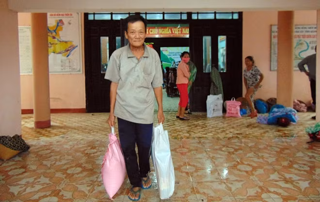 Người dân vùng lũ xã Đại Cường, huyện Đại Lộc vui mừng nhận quà.