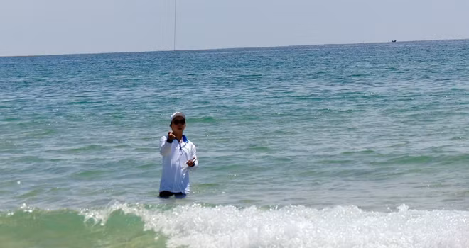Một nghệ nhân lội xuống biển để lấy đà cho diều bay cao.