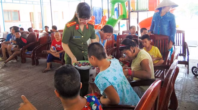 Phát bánh kẹo cho các em nhỏ.